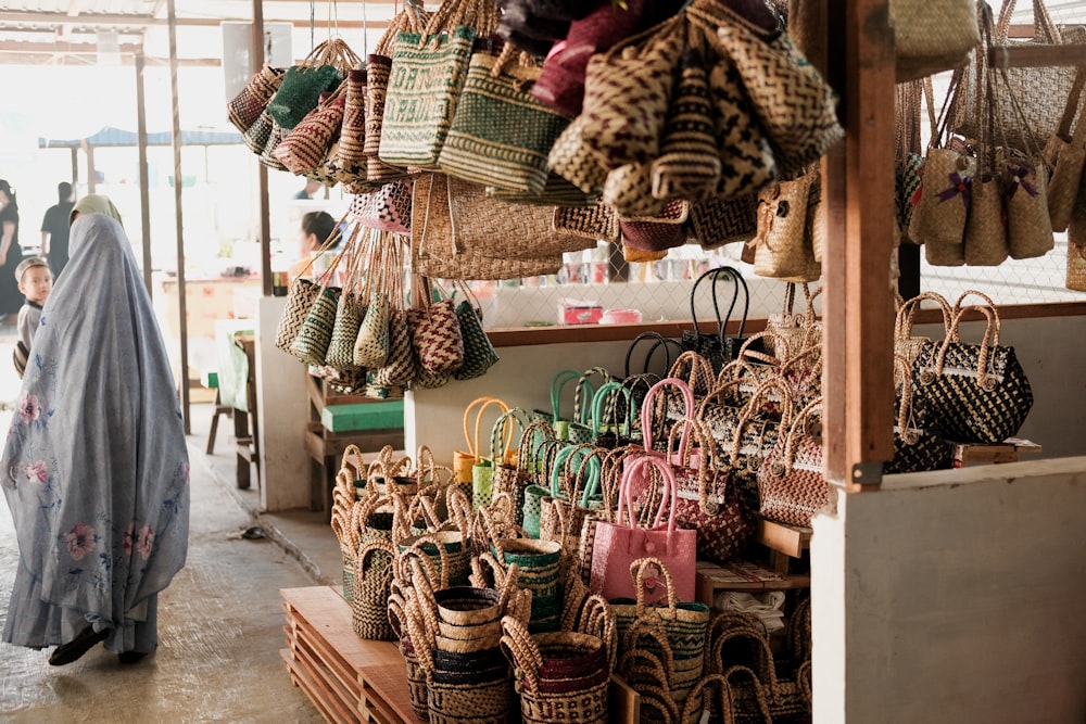 a woman standing in front of a store filled with baskets