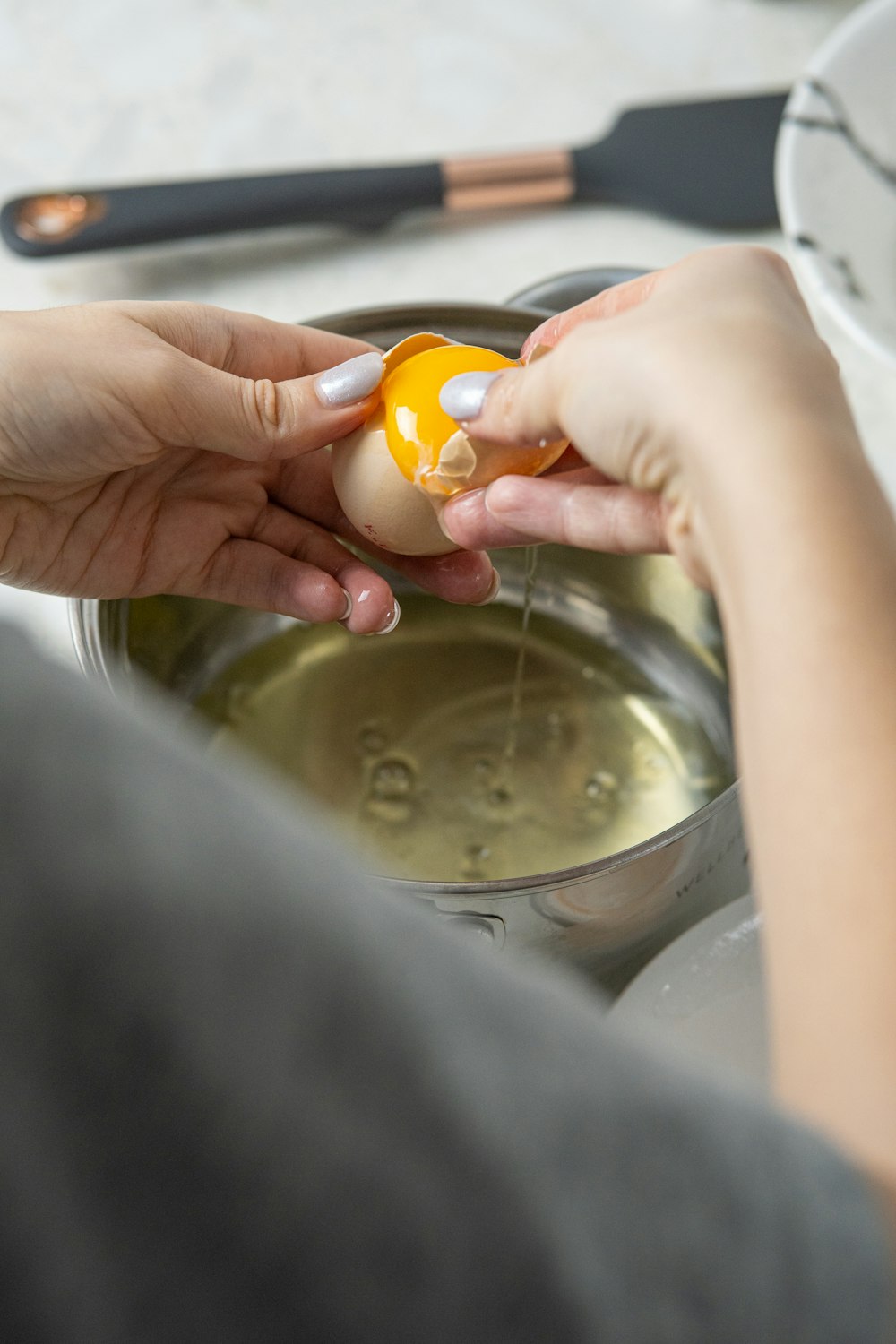 a woman is peeling an egg into a bowl