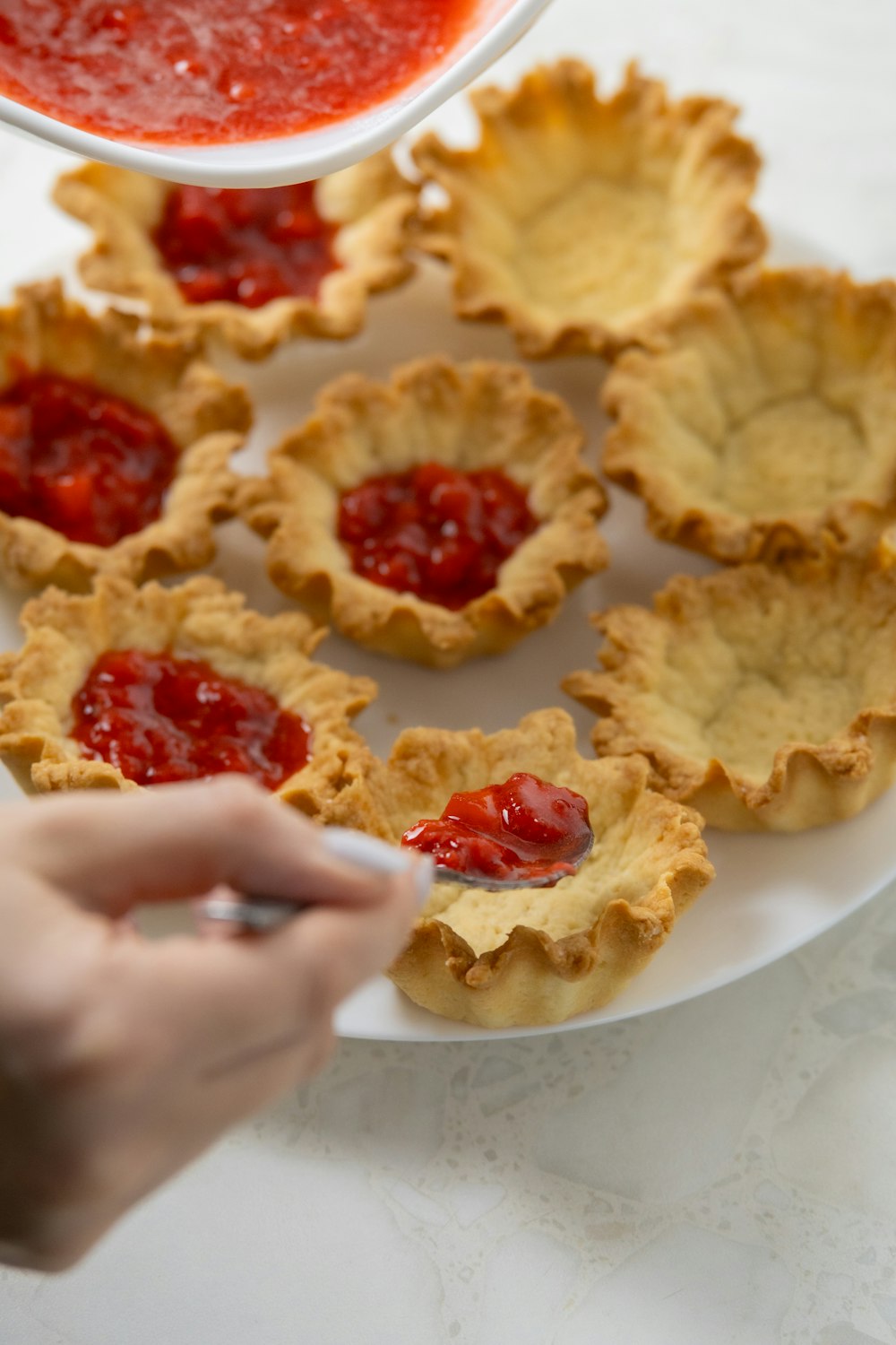 a white plate topped with mini pies covered in jelly