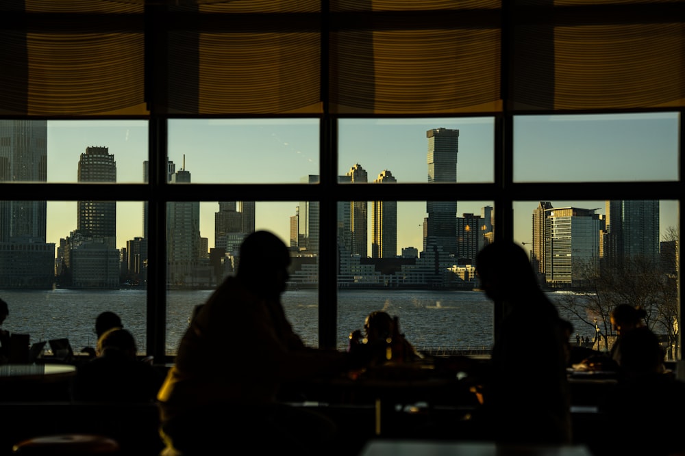 a couple of people sitting at a table in front of a window