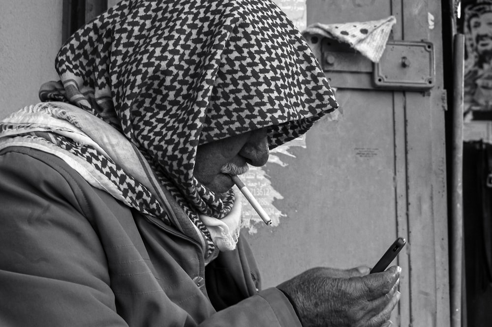 a woman in a headscarf looking at her cell phone