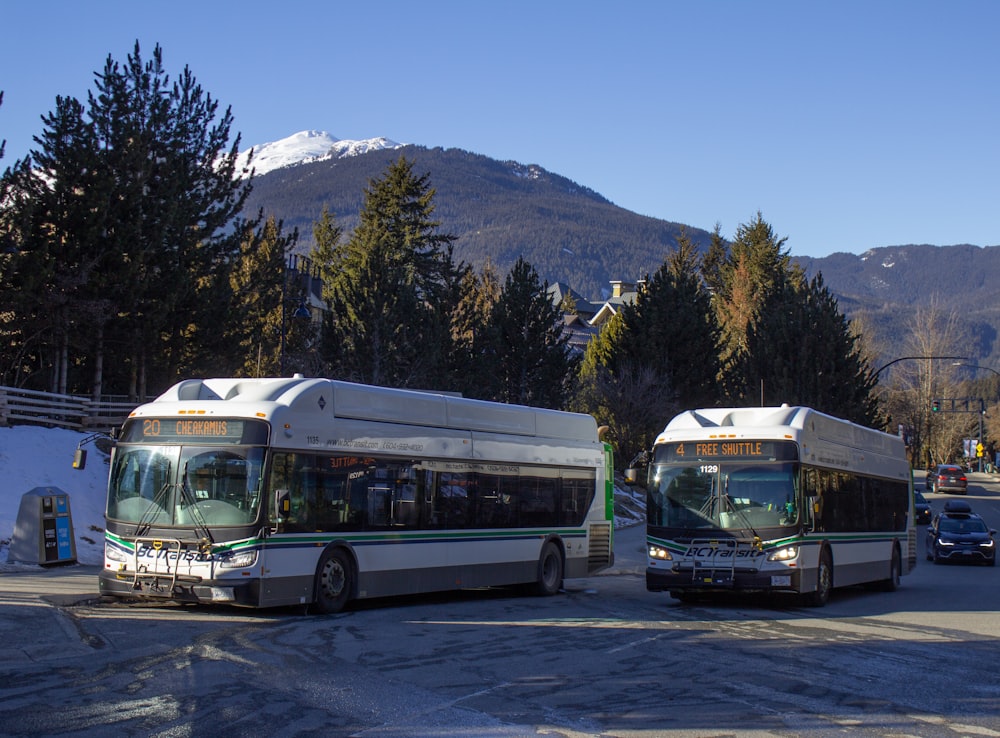 a couple of buses that are sitting in the street