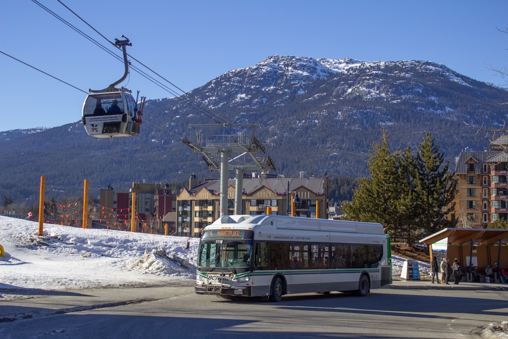 a bus driving down a street next to a ski lift