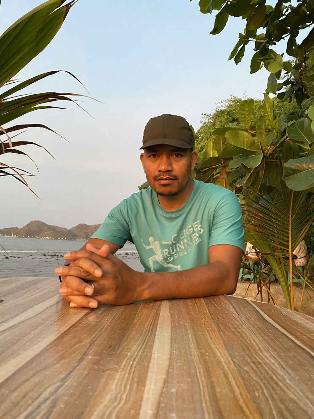 a man sitting at a wooden table with his arms crossed