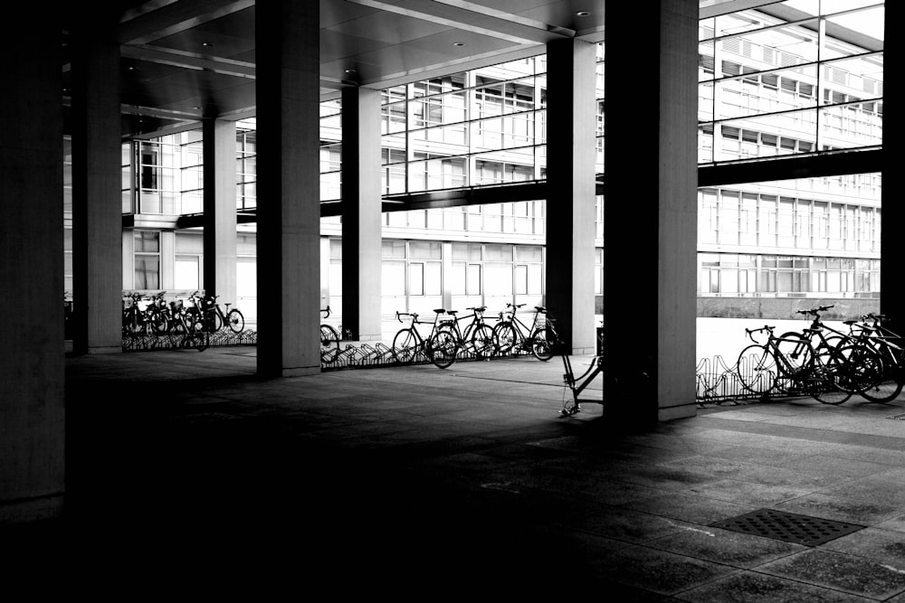 a black and white photo of bicycles parked in a parking garage