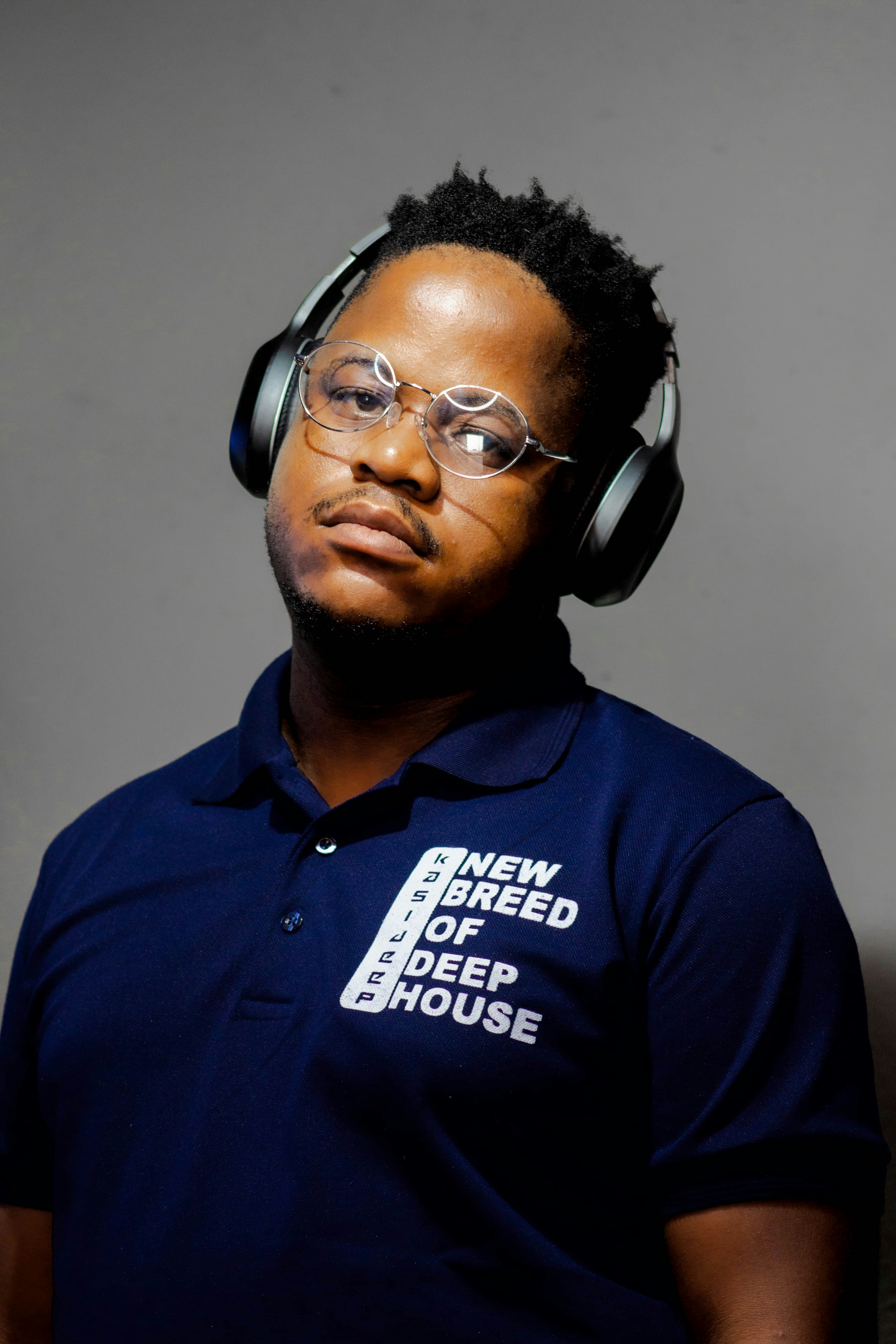 Young man with headphones around neck, relaxed confident pose