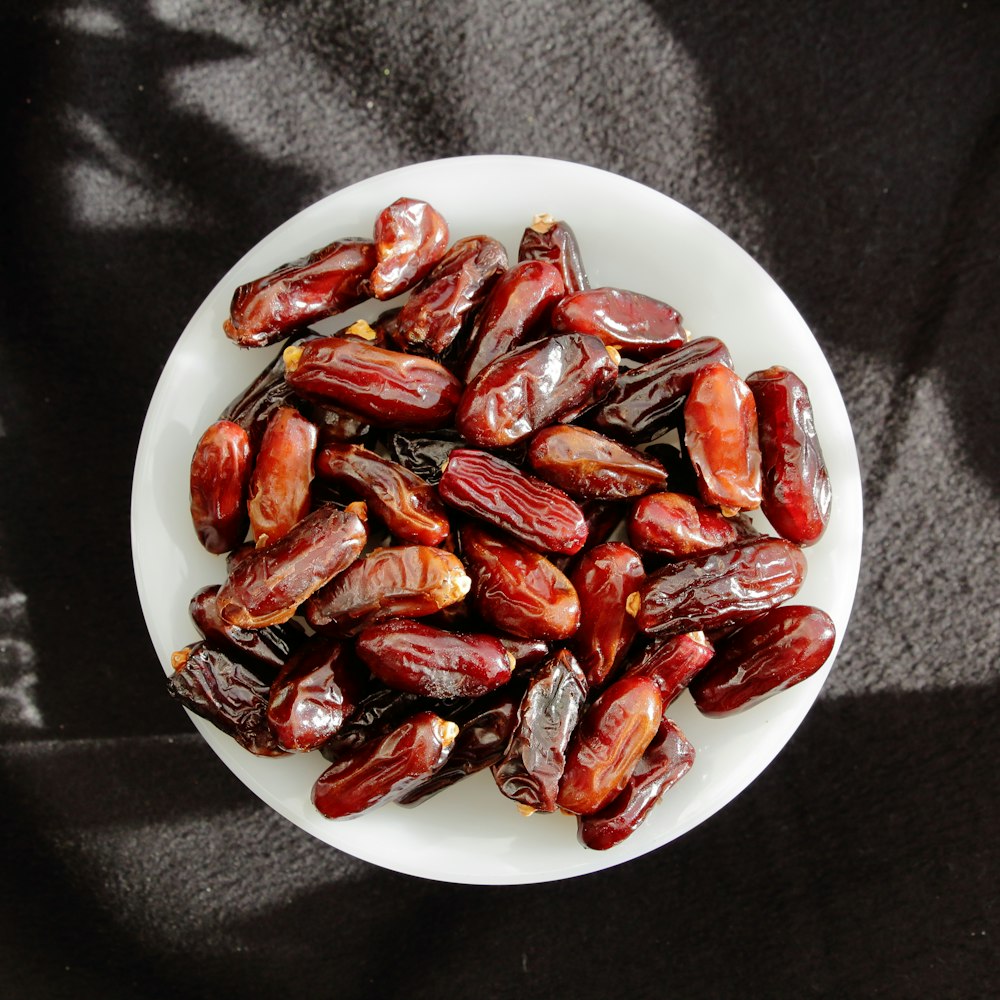a white plate topped with lots of red dates