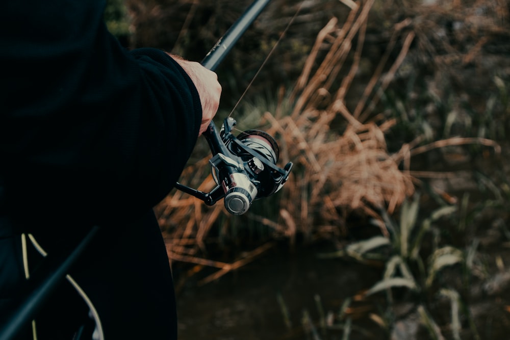 a person holding a fishing rod and a fishing pole