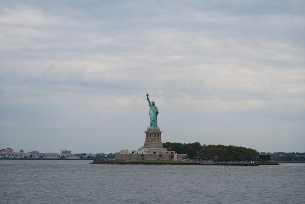 the statue of liberty stands in the middle of the water