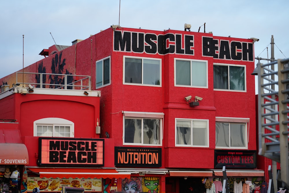 a red building with a sign that says muscle beach