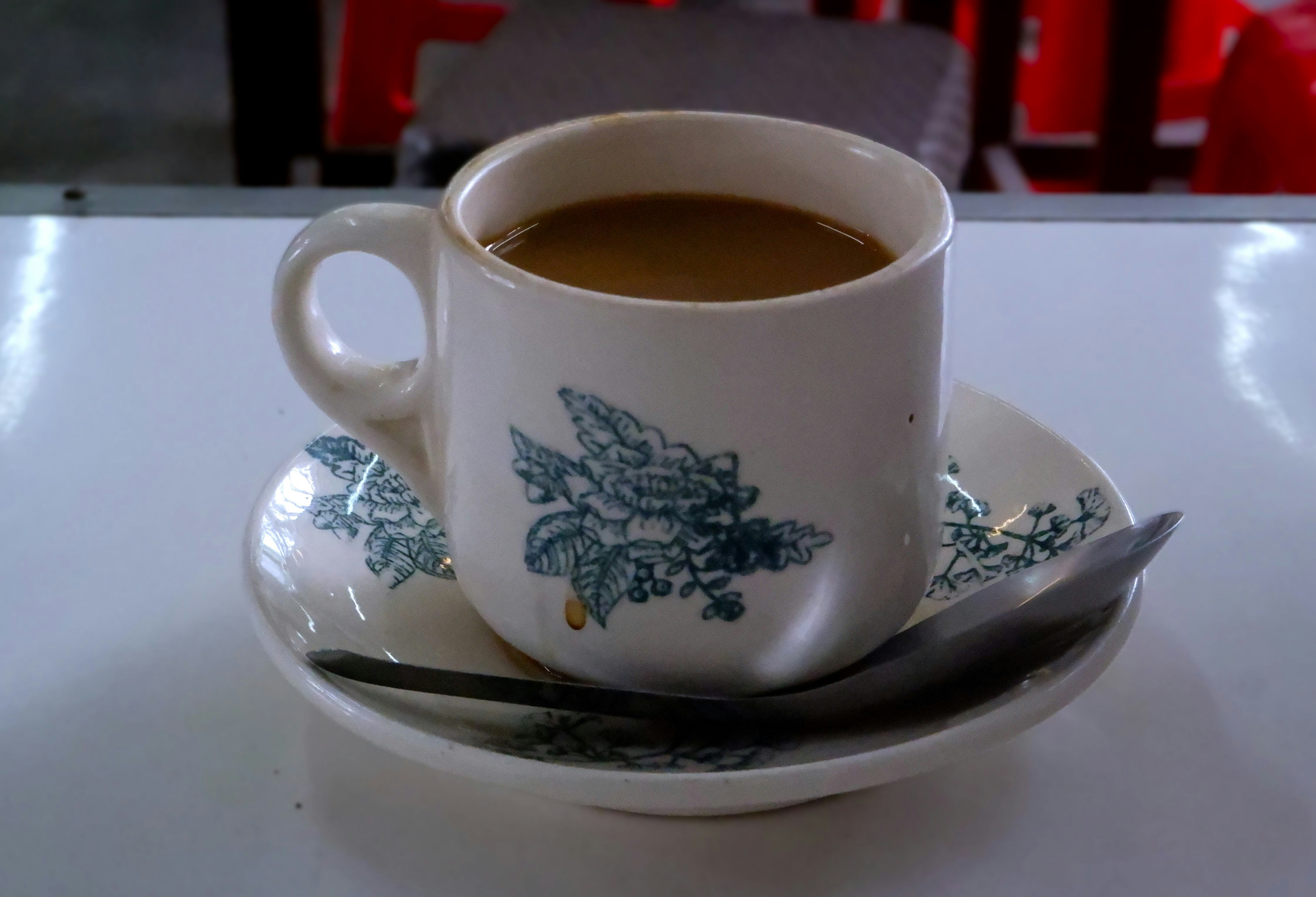 secangkir kopi di atas piring dengan sendok