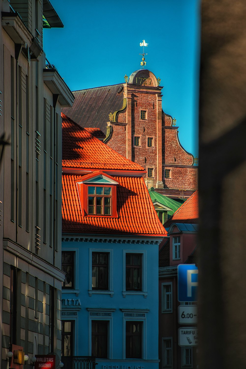 um edifício com um telhado vermelho e uma cruz no topo