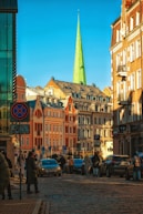 a group of people walking down a street next to tall buildings