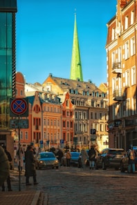 a group of people walking down a street next to tall buildings