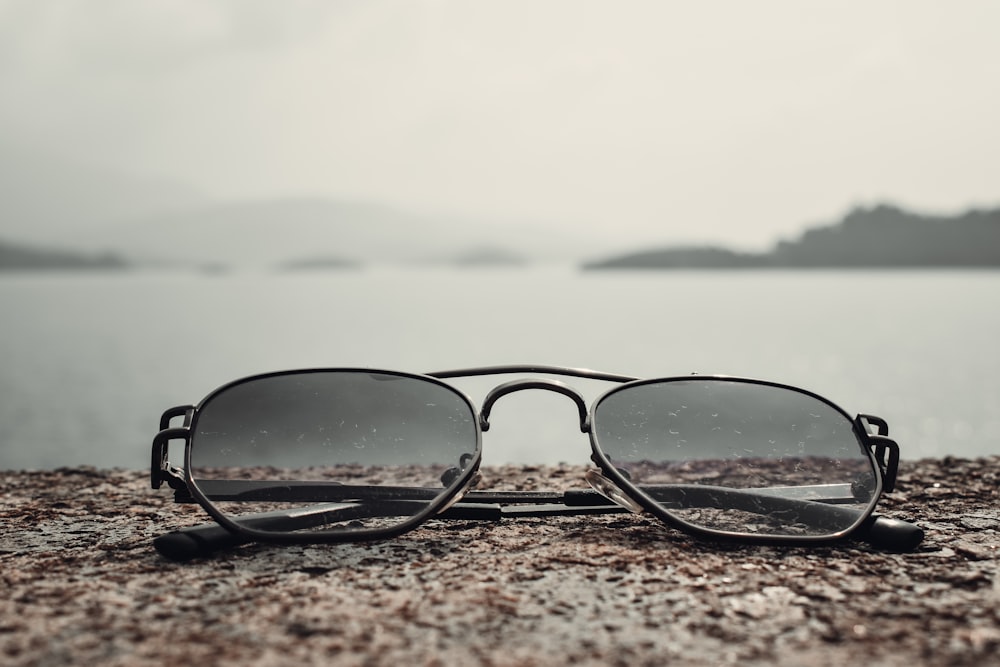 a pair of sunglasses sitting on top of a rock