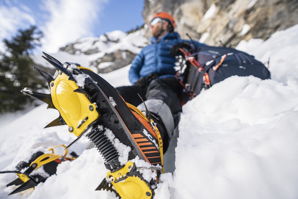 um homem deitado na neve com uma prancha de snowboard presa aos pés