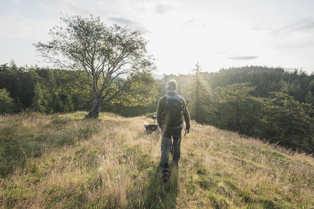 a man walking in a field with a dog