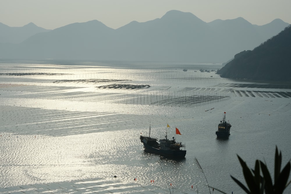 a couple of boats floating on top of a large body of water