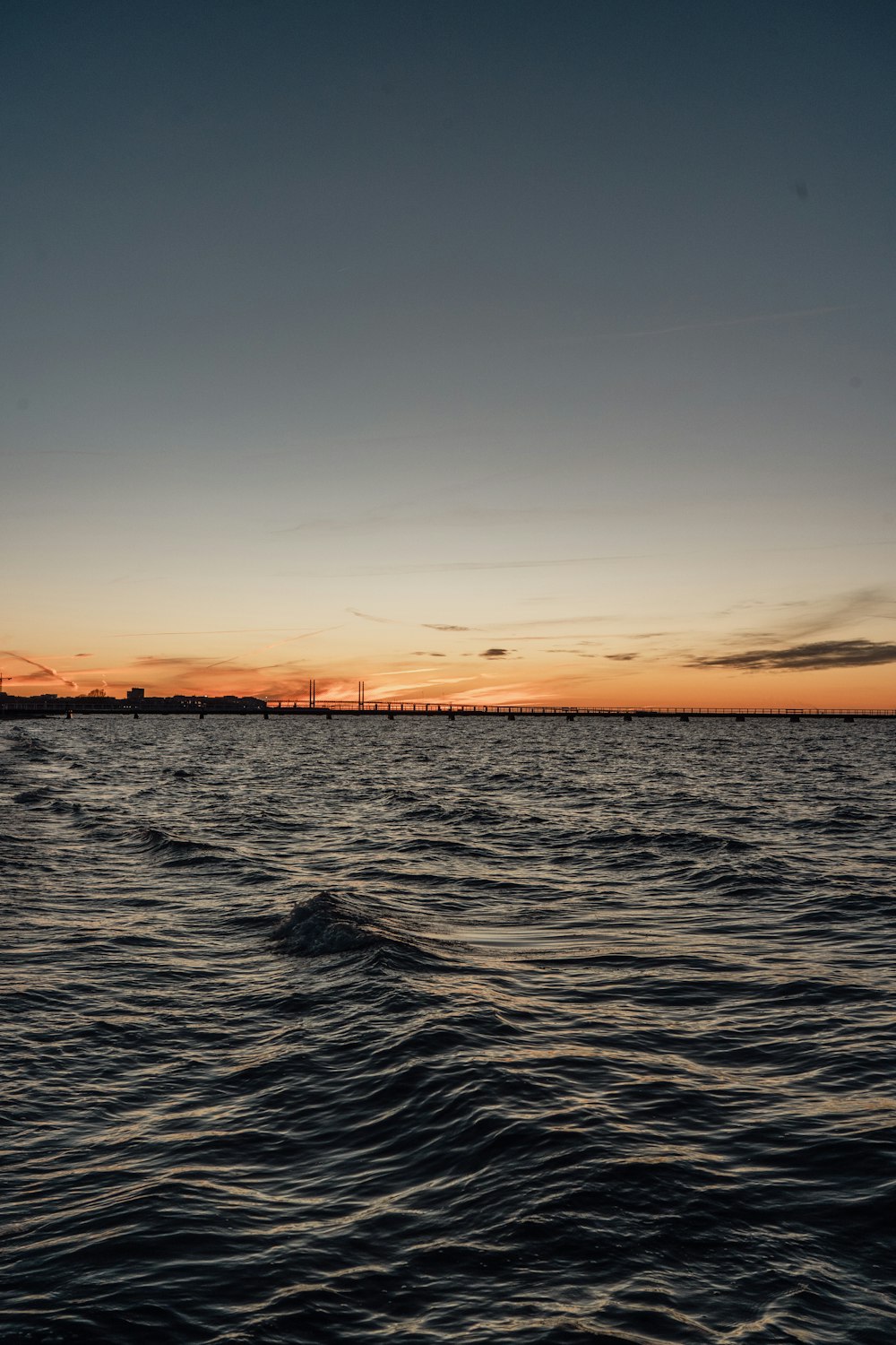 a body of water with a sunset in the background