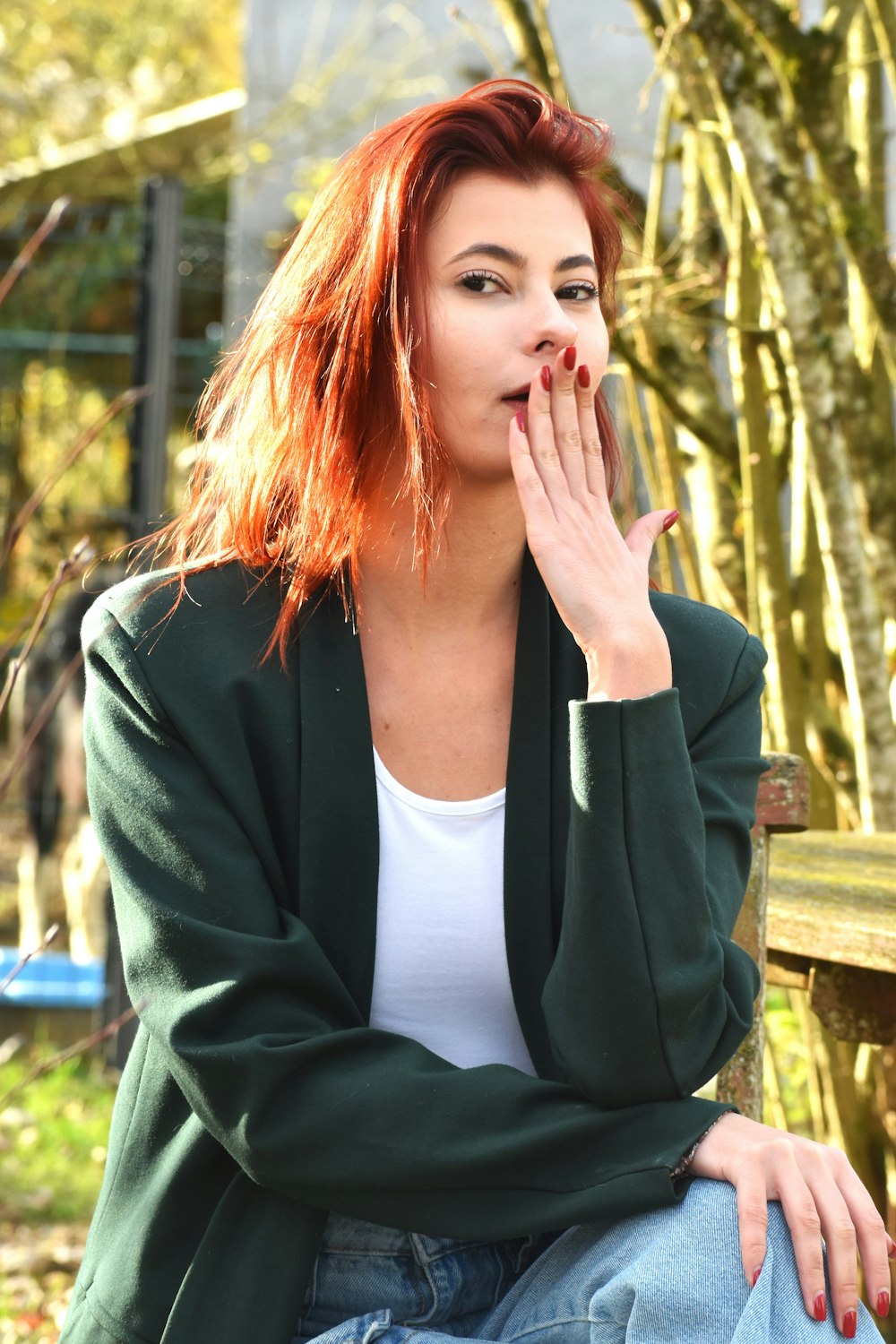 a woman with red hair sitting on a bench