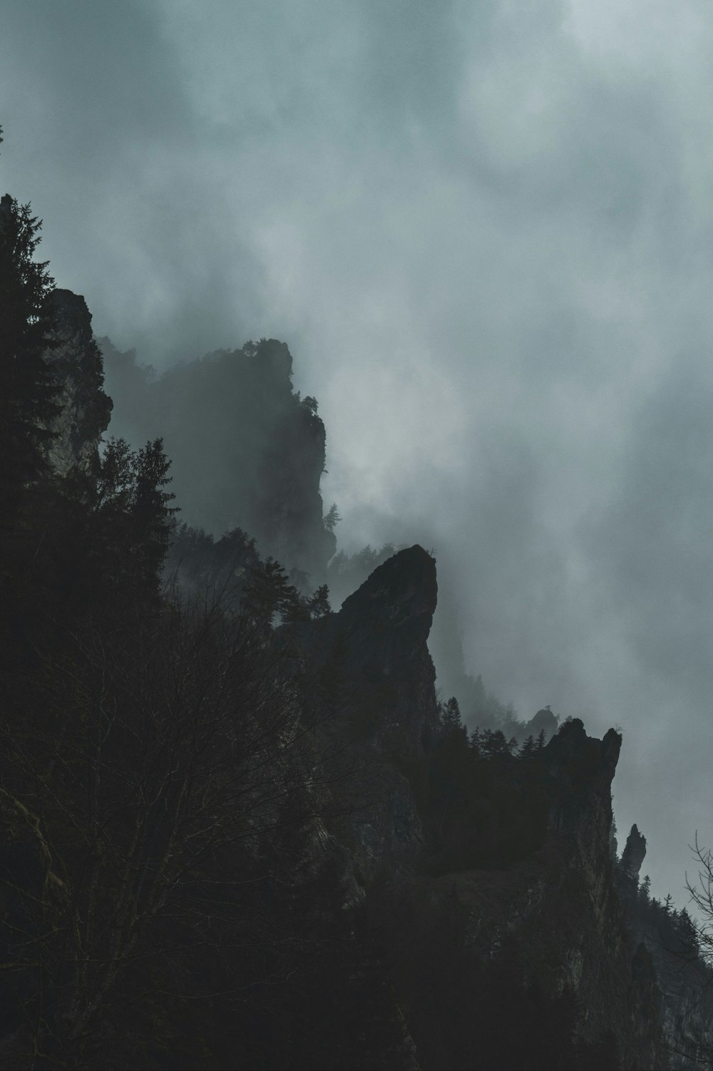 a black and white photo of a foggy mountain