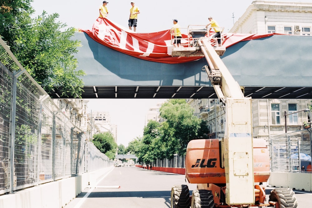 a man on a crane working on a large red banner