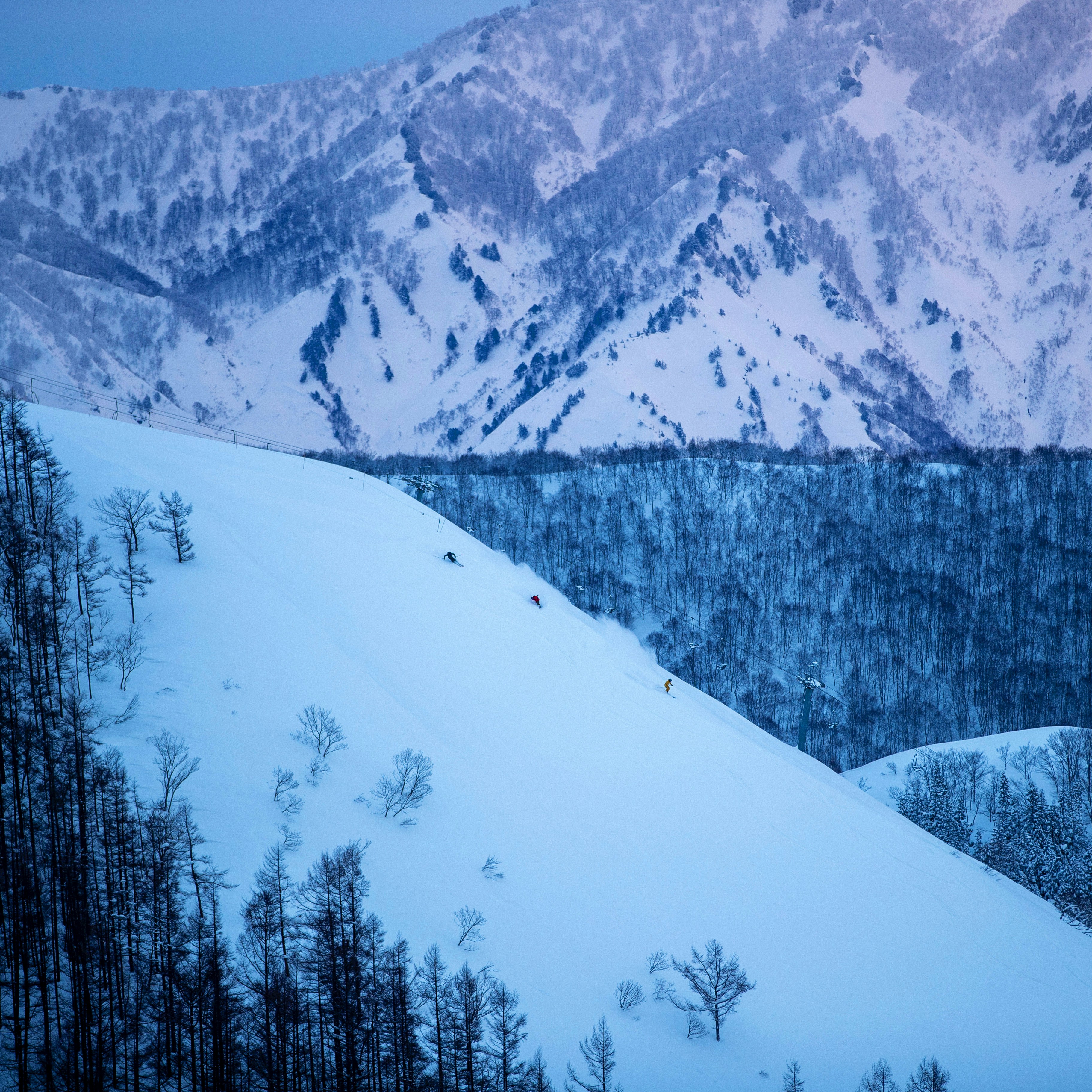 una persona che scia giù per una montagna innevata