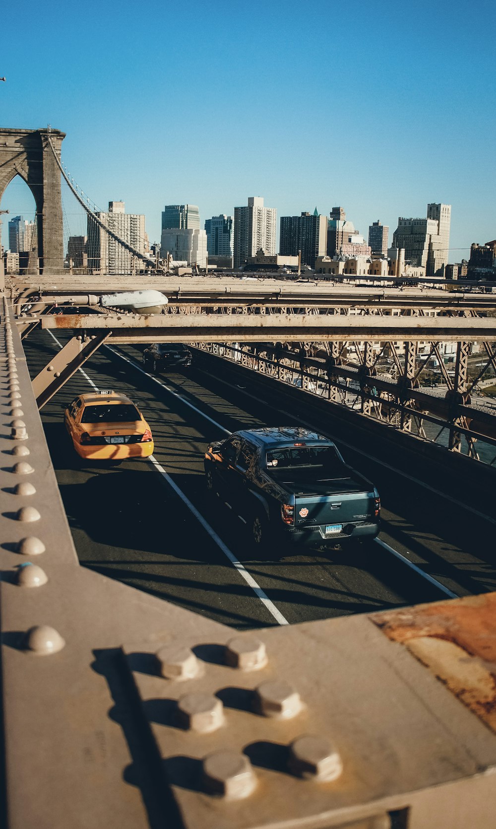 a couple of cars that are driving down a bridge