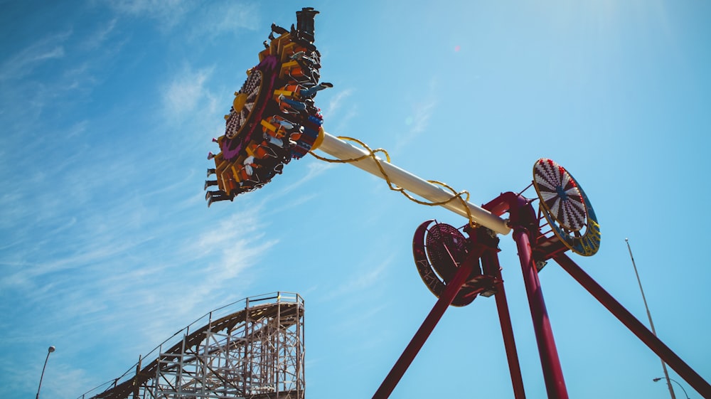 a carnival ride with a roller coaster in the background