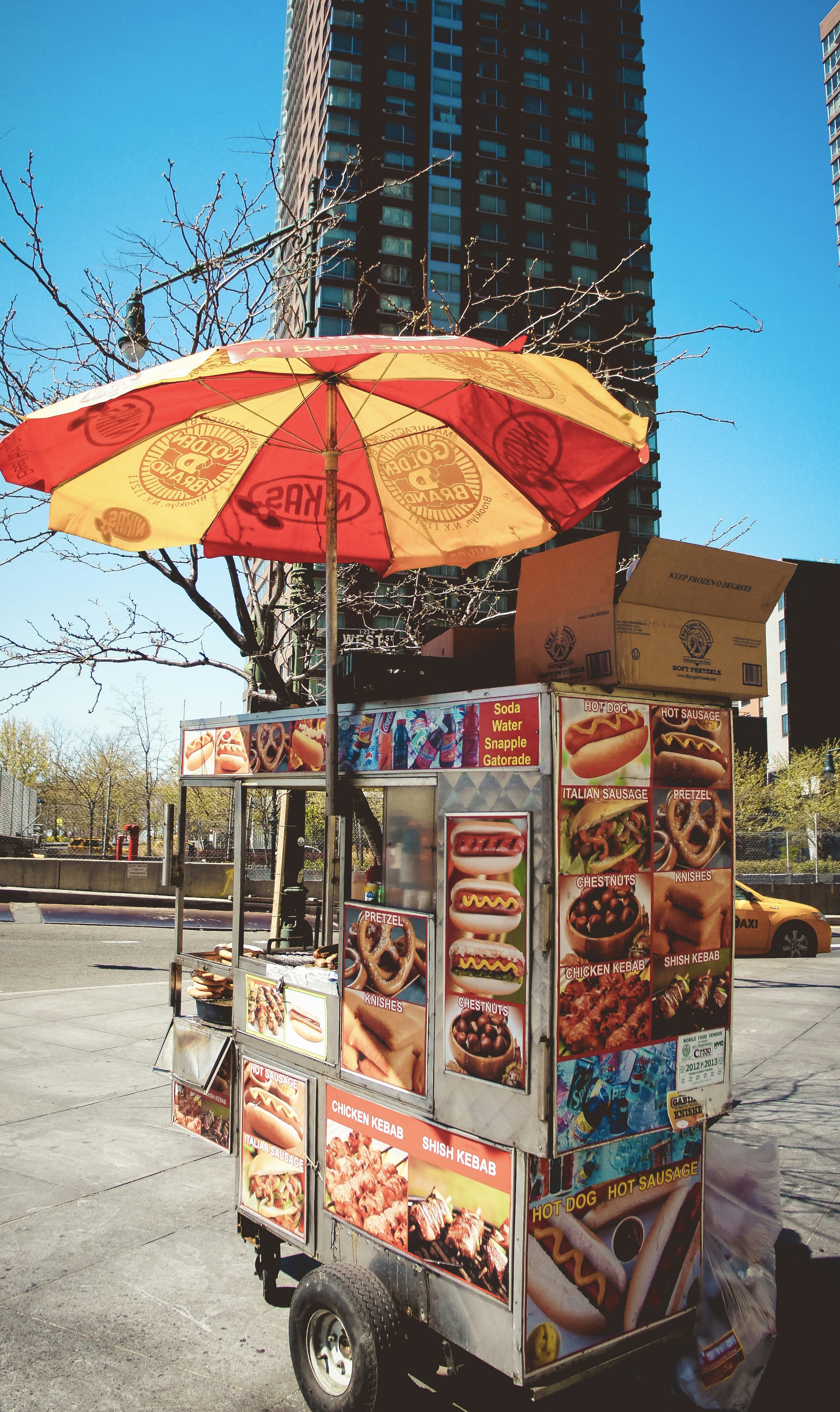 New York City hot dog cart on the street with a colorful umbrella