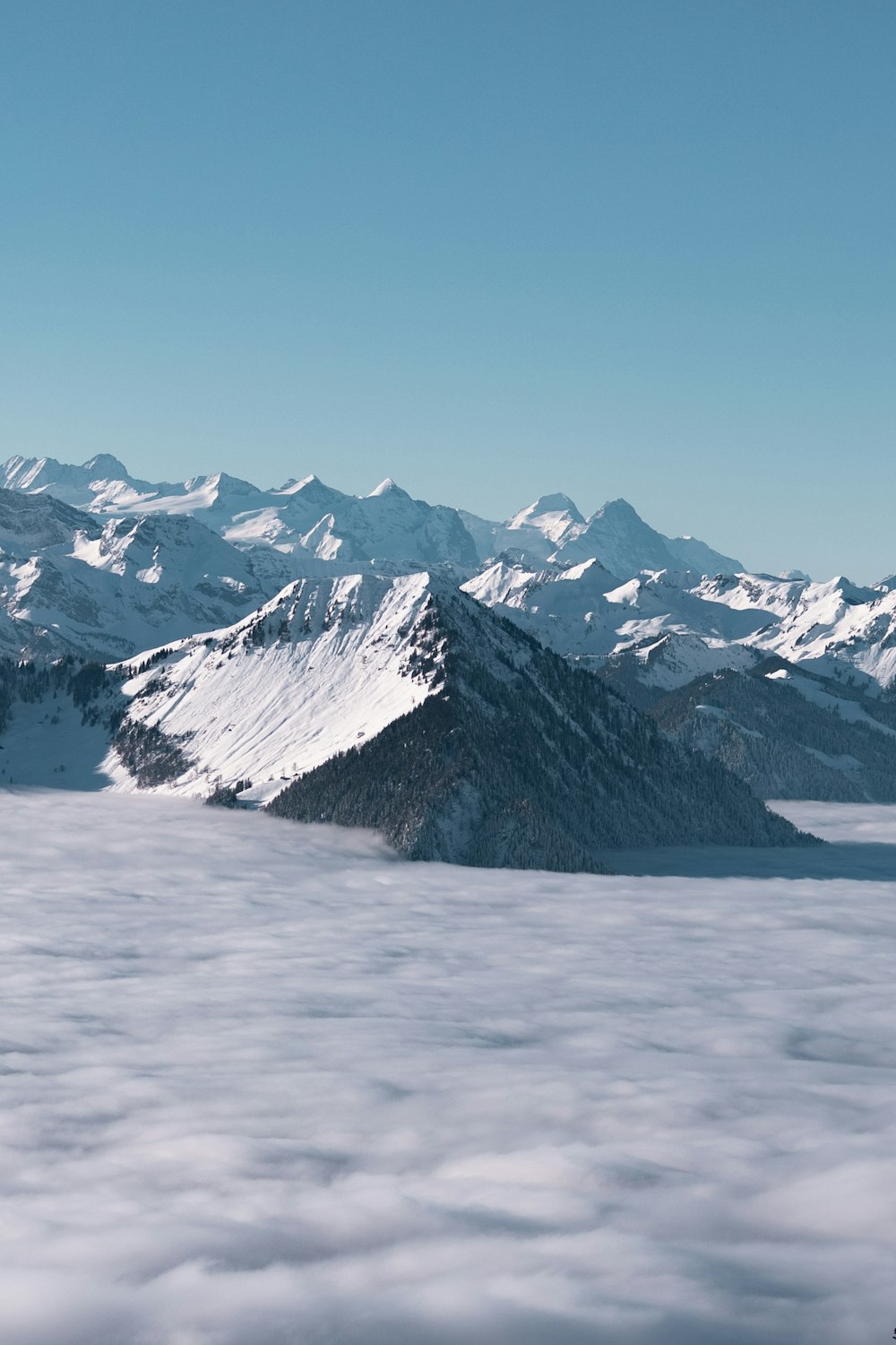 a mountain range covered in snow and clouds