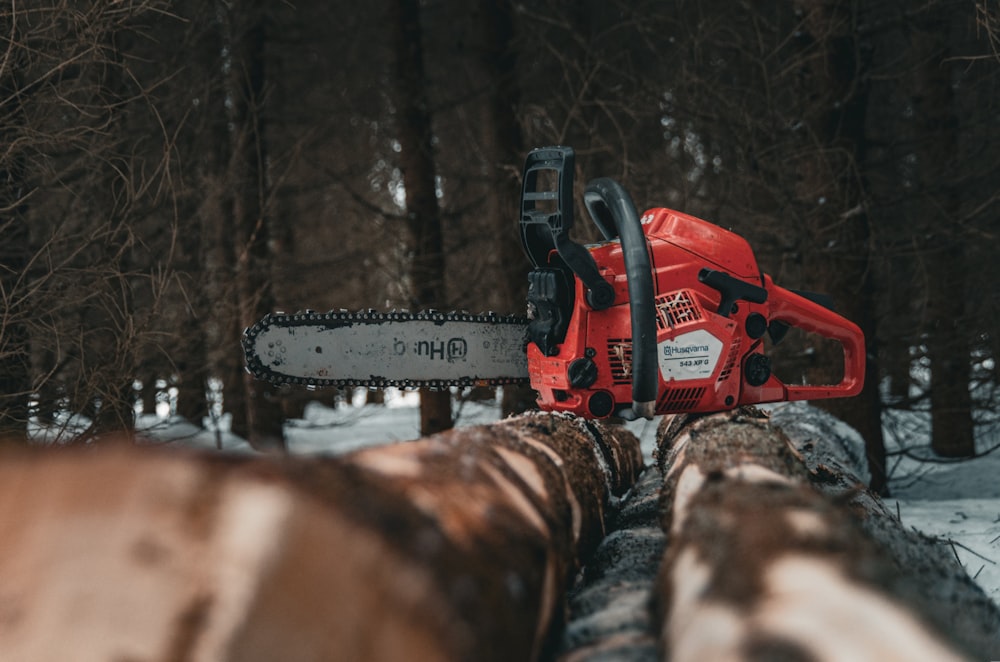 a chainsaw sitting on top of a log in the snow