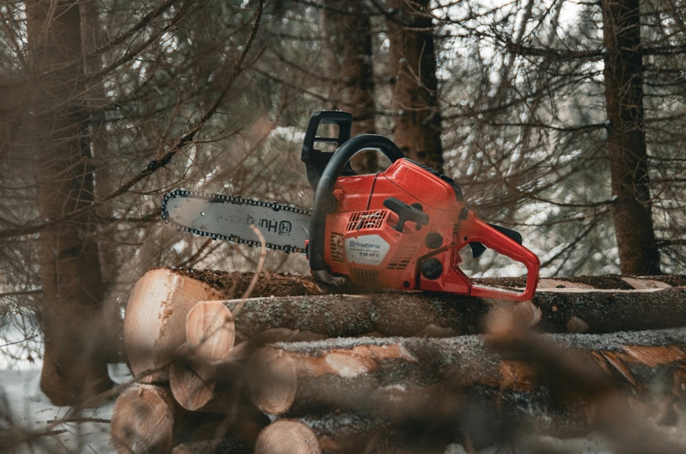 a chainsaw sitting on top of a pile of logs