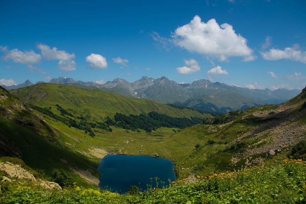 a lake in the middle of a green valley