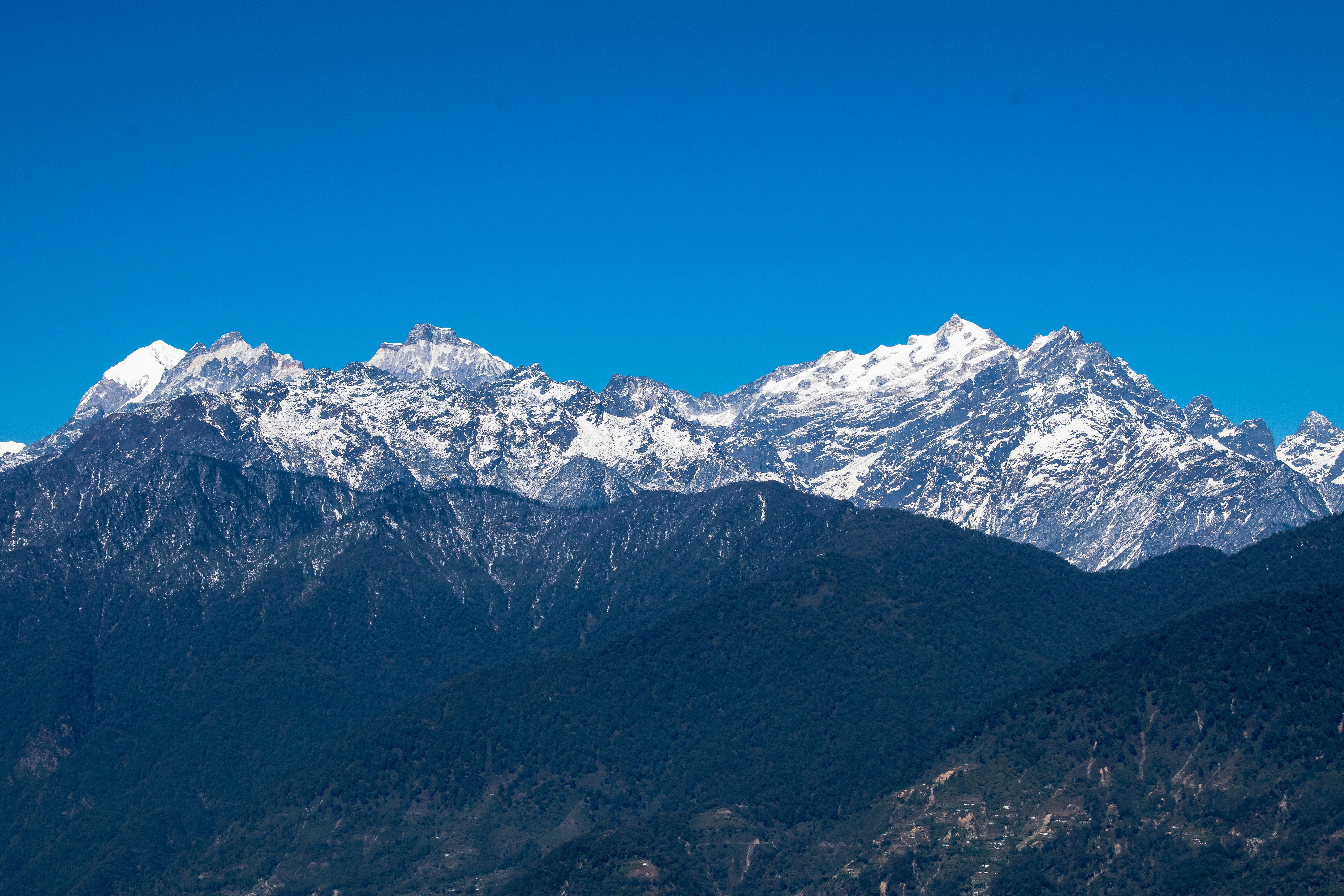 a mountain range with snow capped mountains in the background