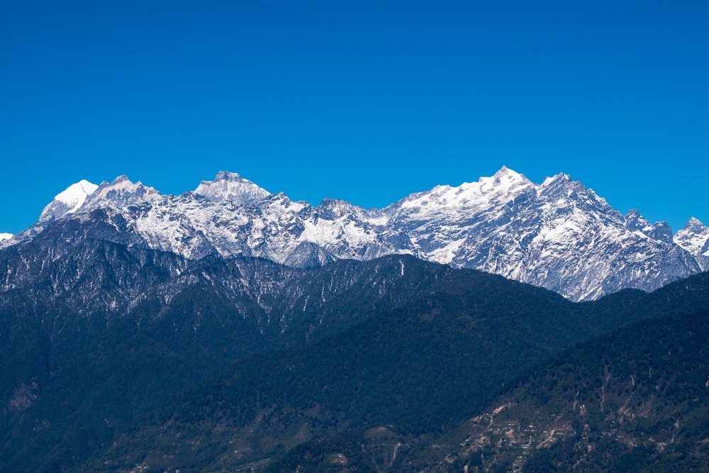 a mountain range with snow capped mountains in the background