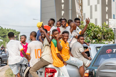 a group of young men riding on the back of a truck