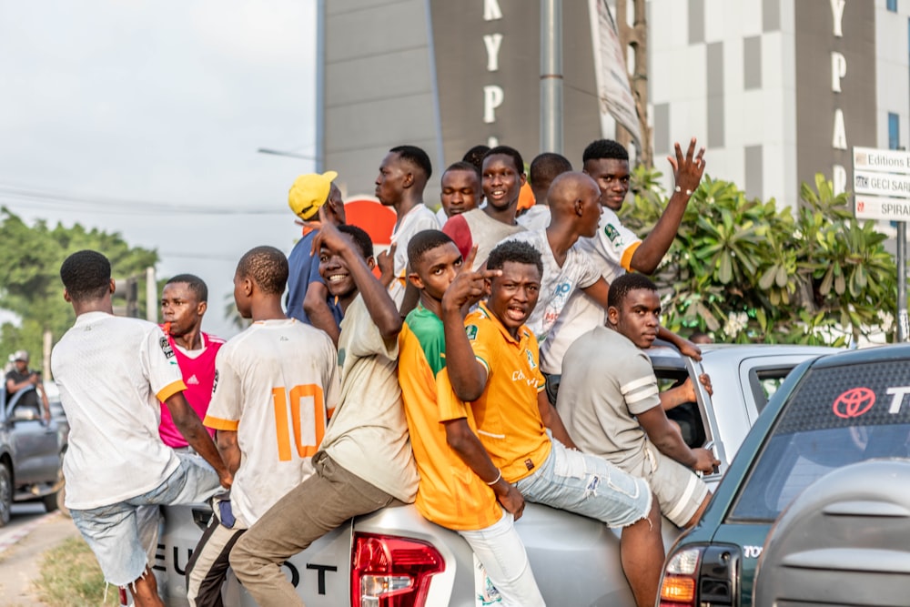a group of young men riding on the back of a truck