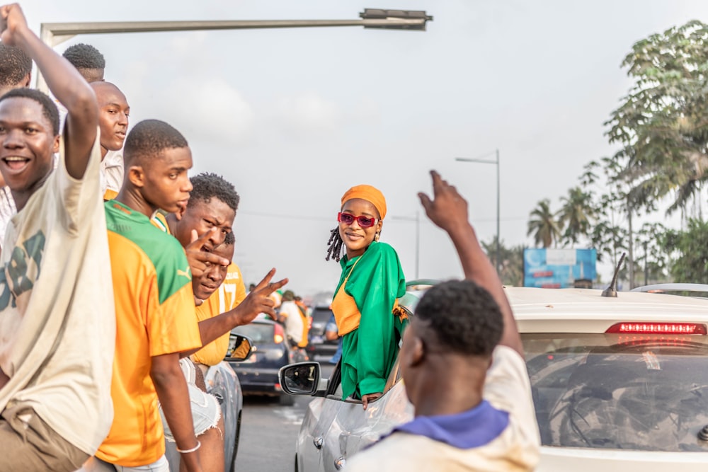 a group of people standing in front of a car