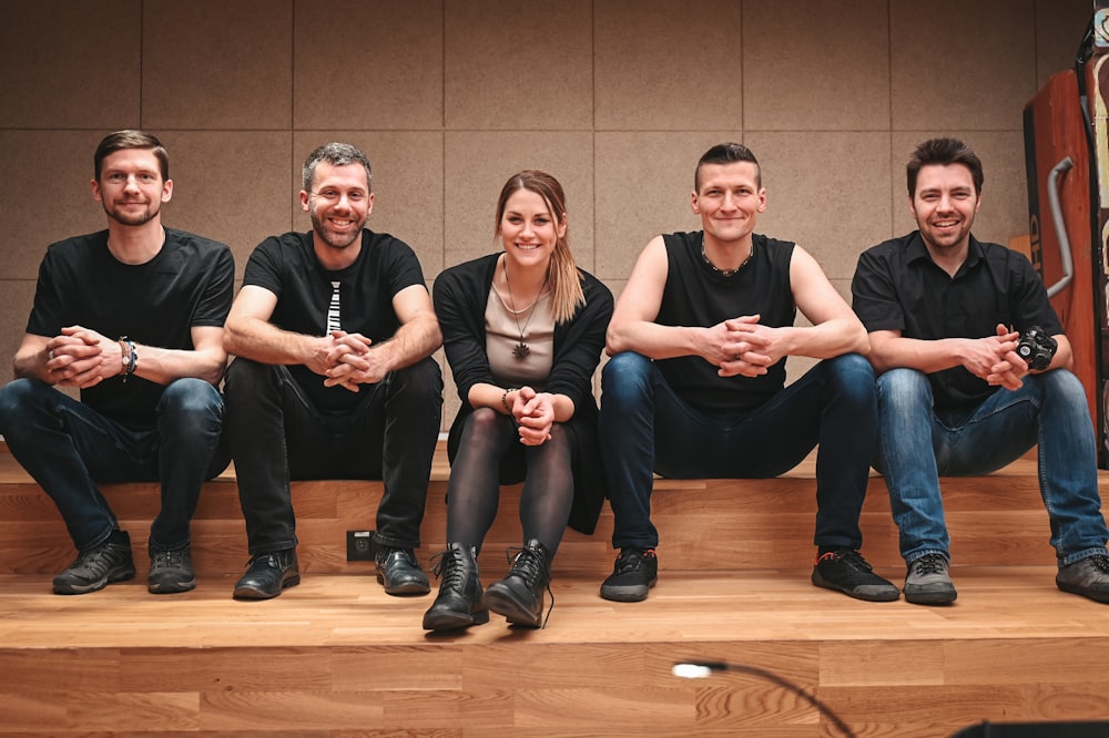 a group of people sitting on top of a wooden step