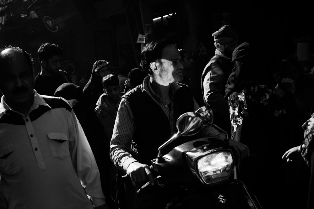 a black and white photo of a man on a motorcycle