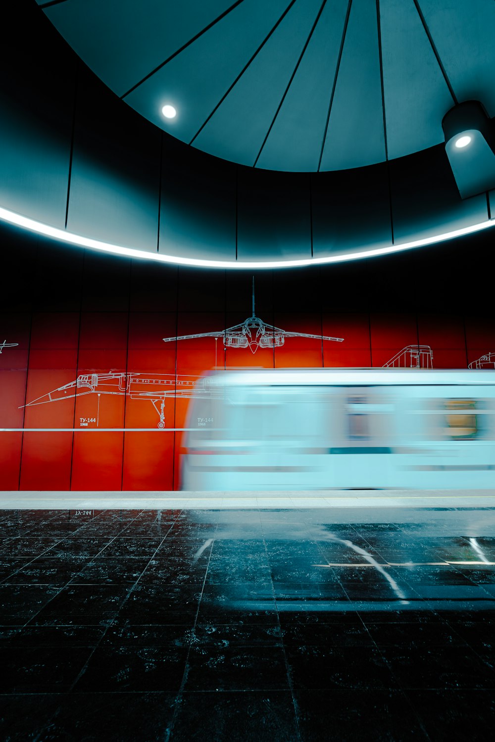 a blurry photo of a train passing by a red wall