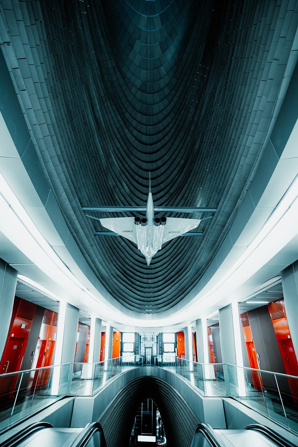 an airplane is flying over an escalator in a building