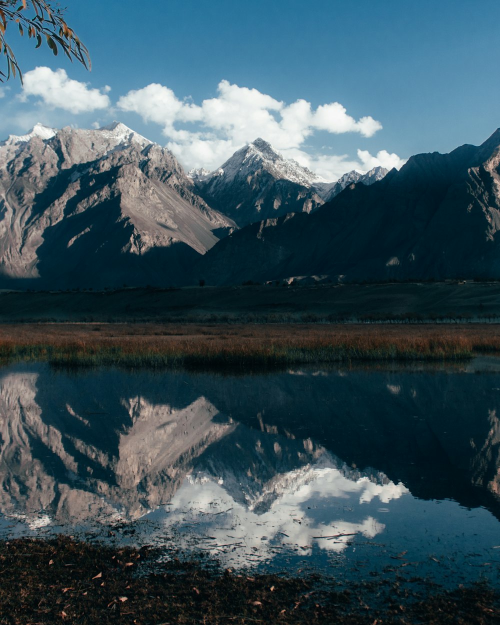 a mountain range with a lake in the foreground