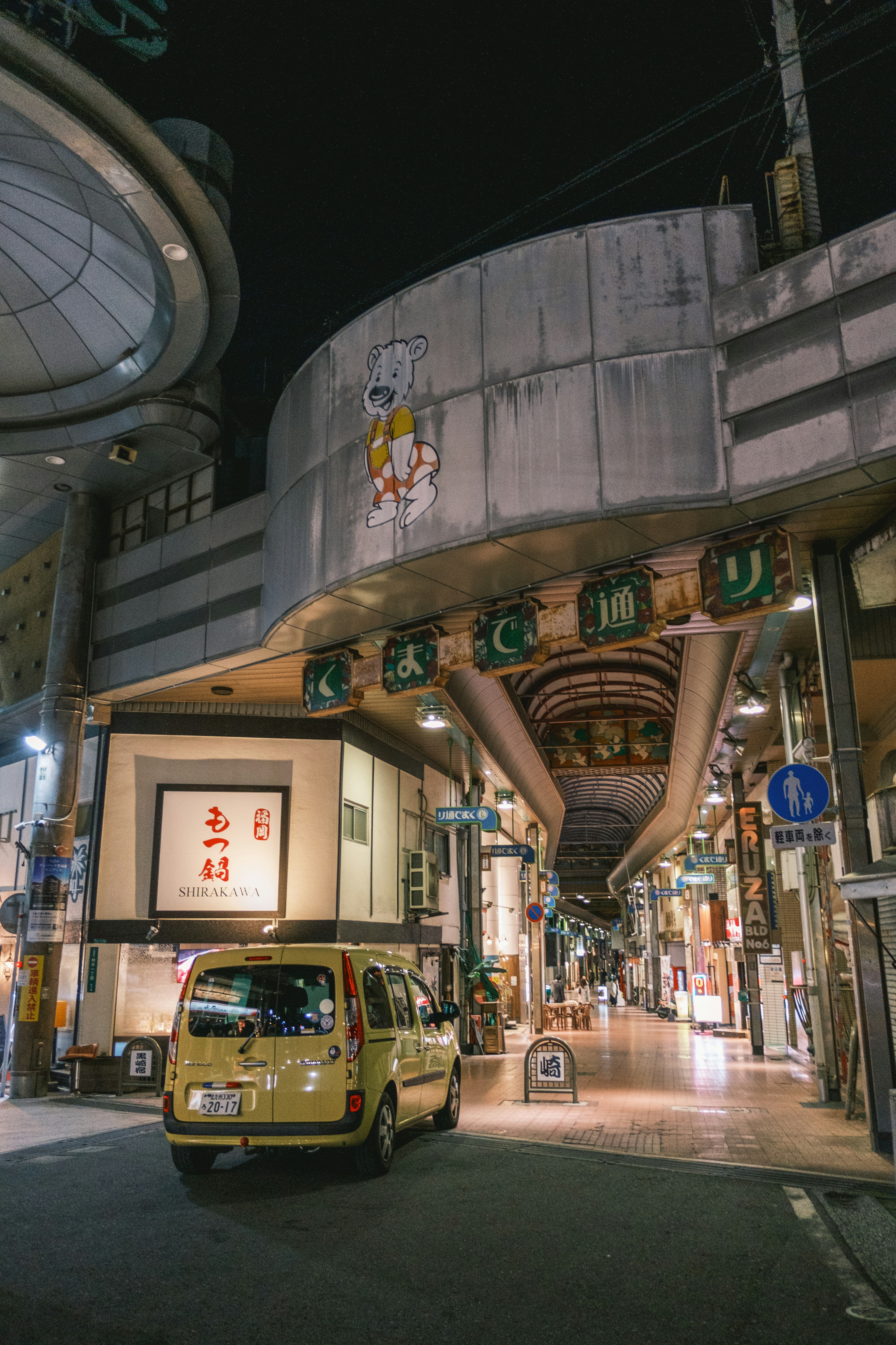 建物の前に黄色いバンが停まっています
