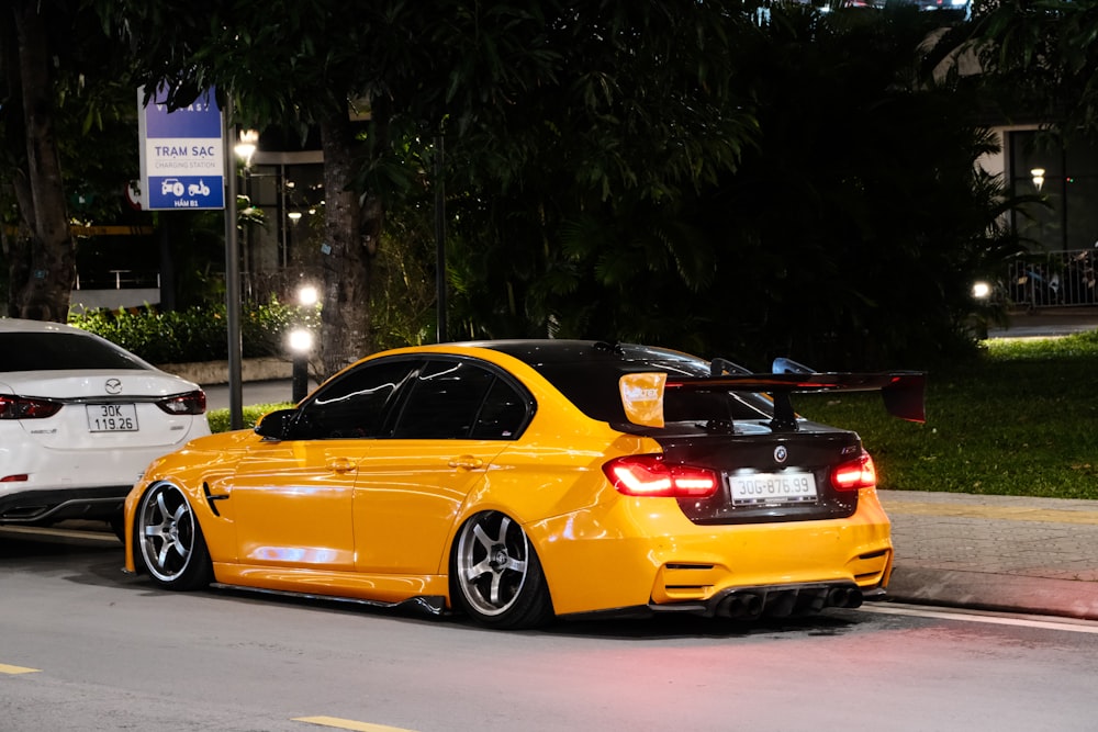 Un coche amarillo está aparcado junto a otro blanco