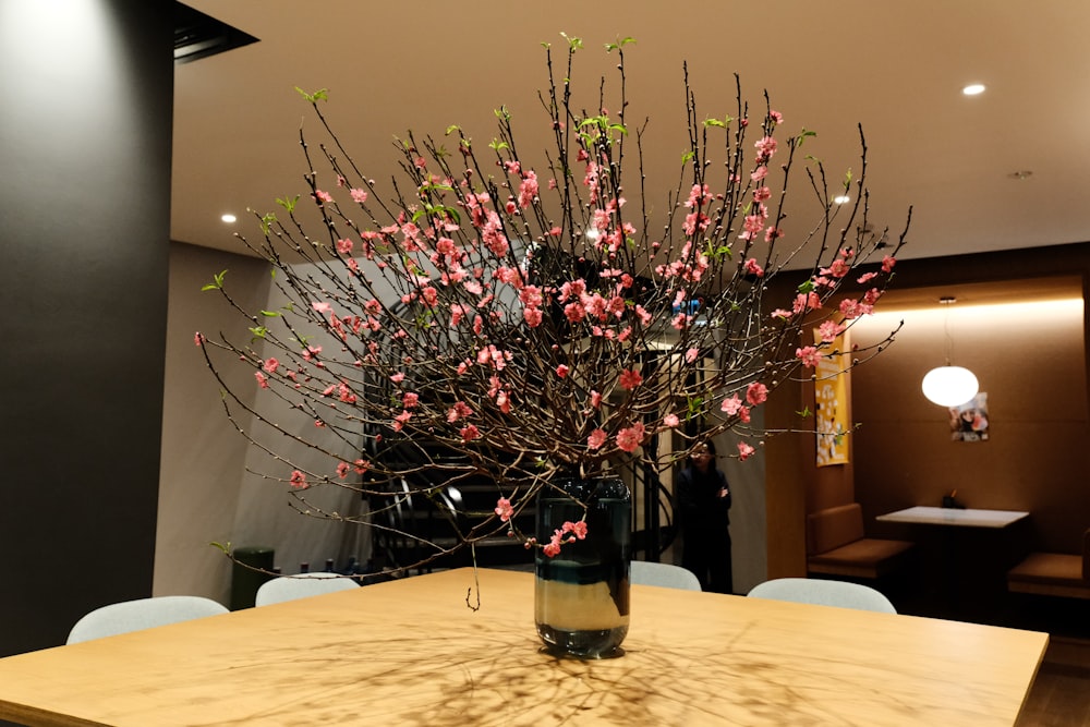 a vase filled with pink flowers on top of a wooden table