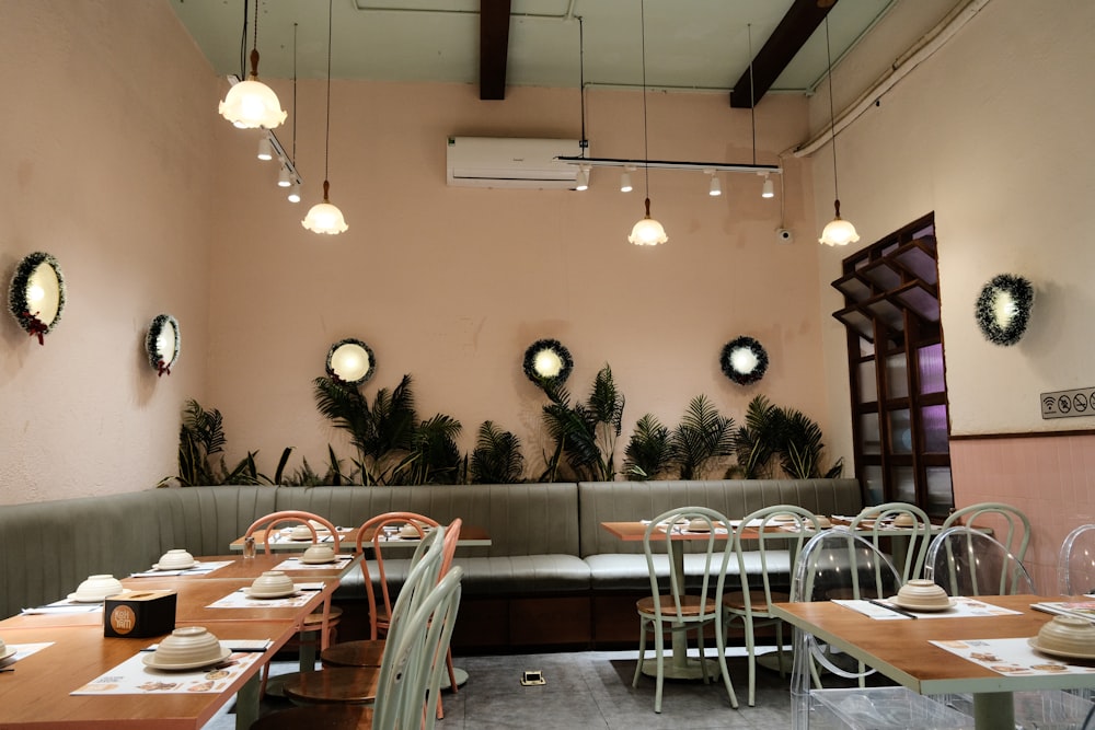 a restaurant with tables and chairs and plants on the wall