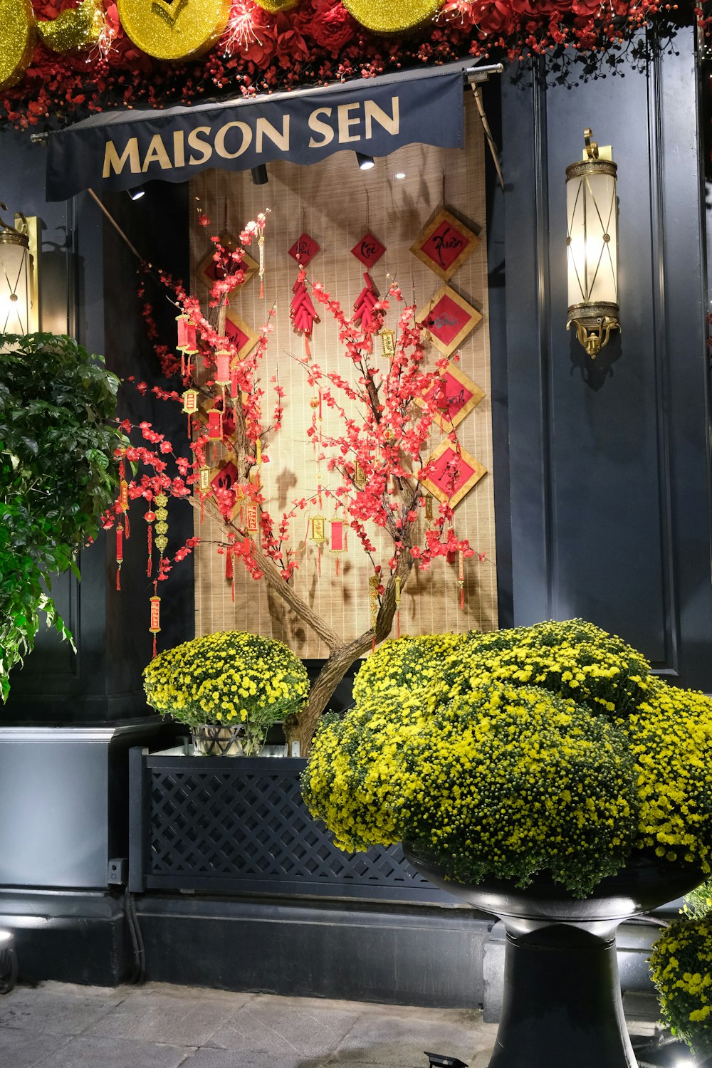 a store front with a display of red and yellow flowers