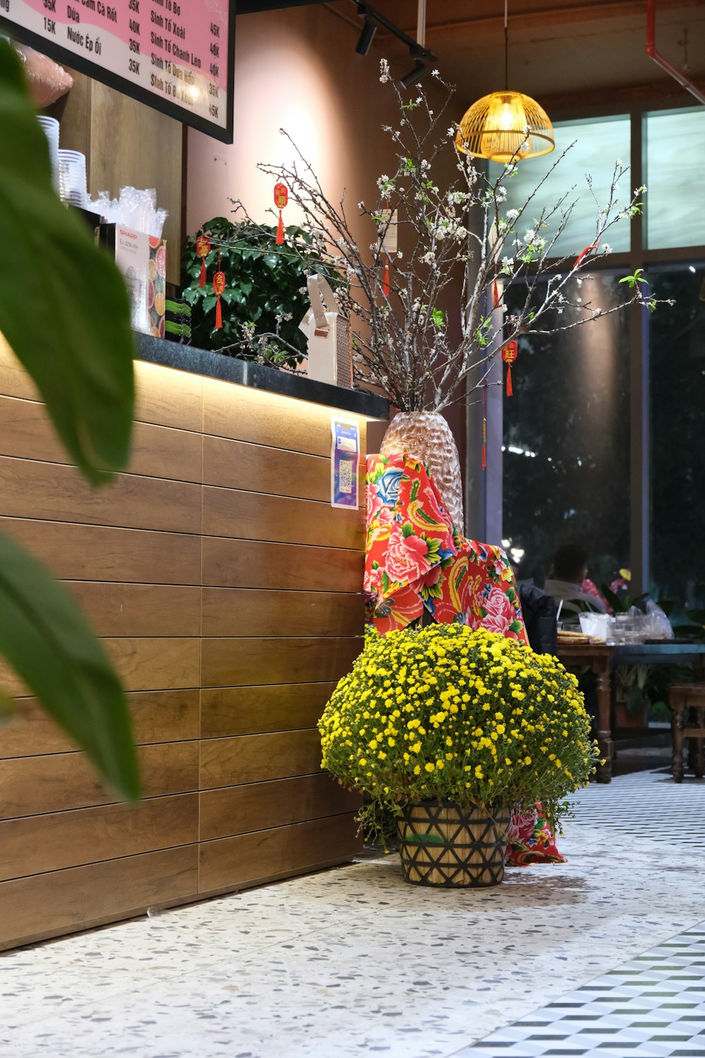 una maceta con flores sentada junto a una pared